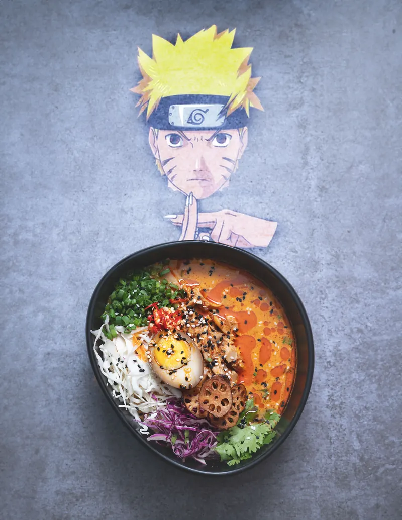 Naruto cut-out peeking over a Fire Bowl ramen, the dish that started Ichiraku's