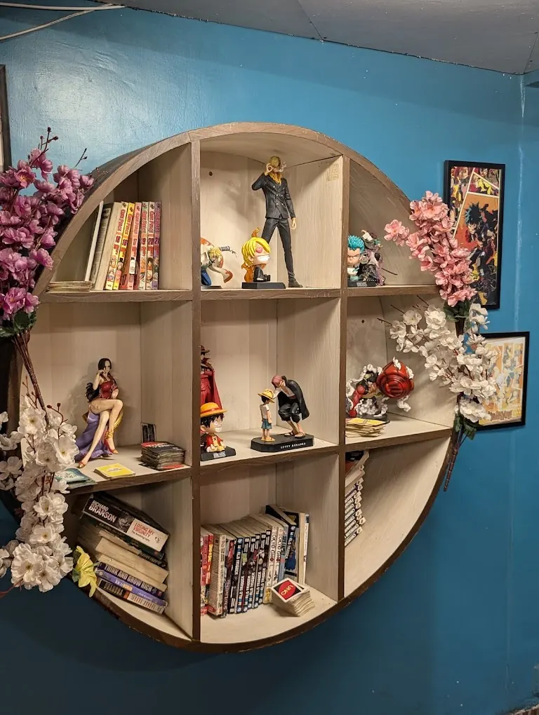 Round wooden shelf of manga and figures on a teal wall