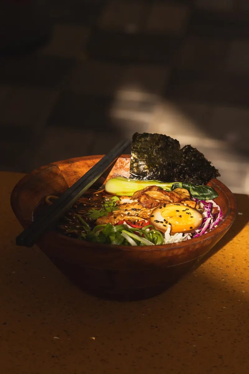 Shoyu ramen in a wooden bowl in warm evening light